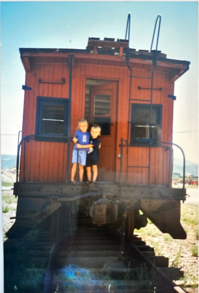Karen and Ezra stand on a caboose.  around 1994. 