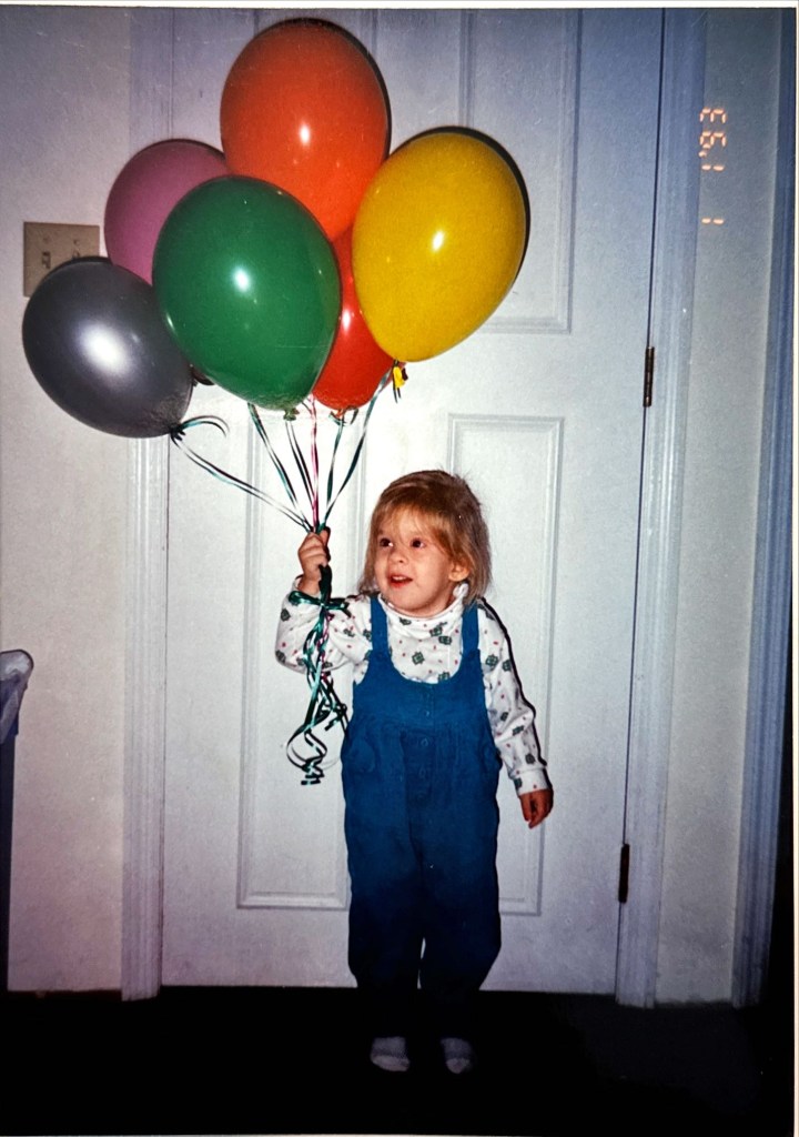 3 year old Karen holds balloons to bring in the new year in 1993