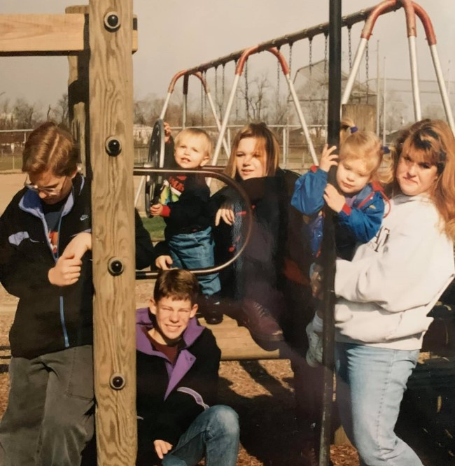 the six siblings in a picture on a playground.  no one looks happy.  