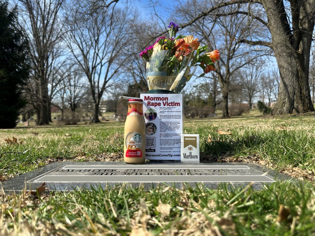 My sister’s grave. There are flowers, white roses and spring colors. I censored her real name and death date with sticks. I brought a few of her favorite things: Starbucks coffee and Marlboro Lights. We smoked one together.