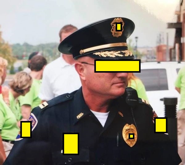 a cop stands coply while in a cop uniform